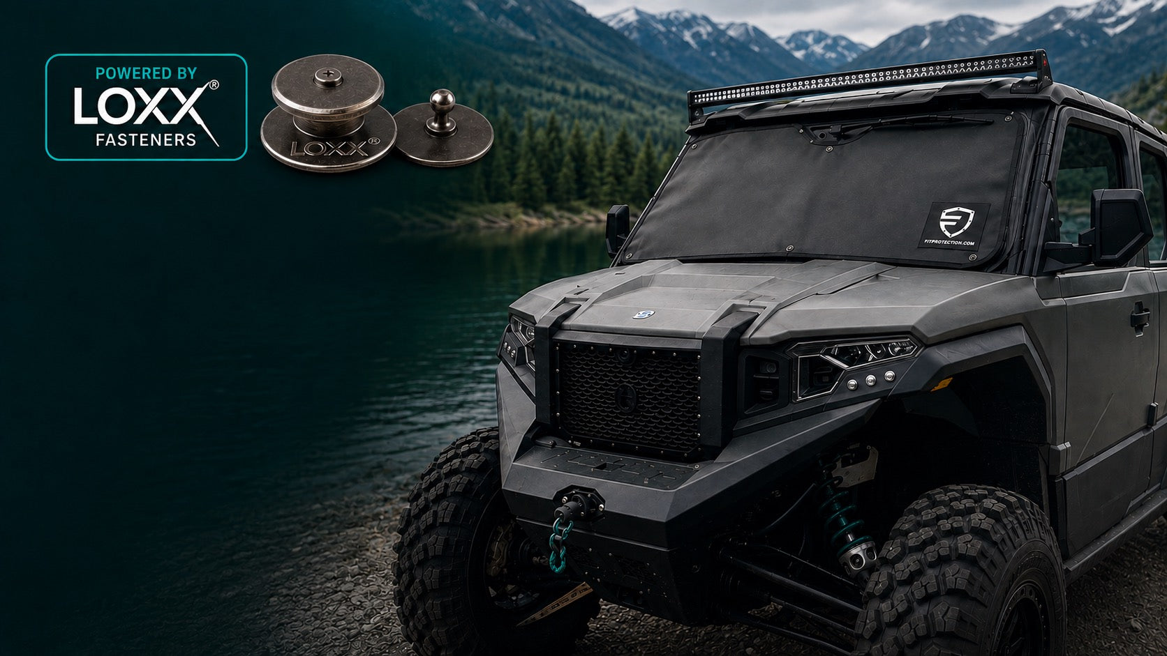 A FIT Protection cover fitted to a UTV windshield beside a mountain lake, shown with two LOXX® fasteners